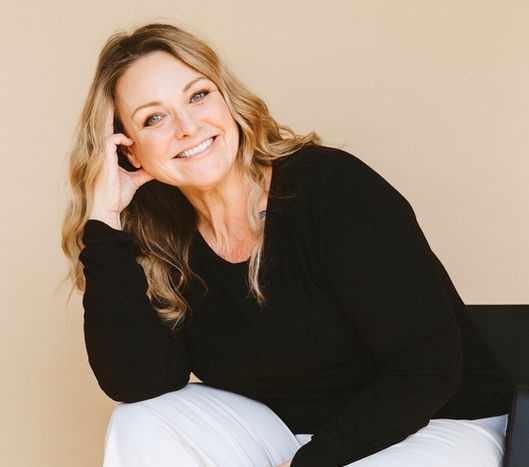 Kim Norwood seated against a tan studio background